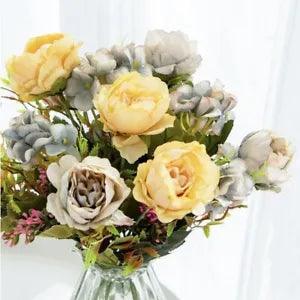 Silk peony flower bouquet with yellow and cream blooms, gray eucalyptus leaves in vase