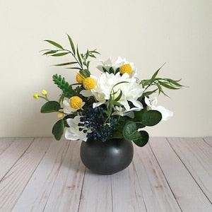 Faux floral arrangement in white, yellow, blue and green