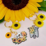 Sunflower skeleton keyring. Flower skull or ribcage keychain. Gold tone novelty keyring with yellow sunflower and skeletal charms.