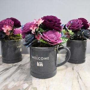 Welcome them with flowers that will last! (price per) large coffee mug with burgundy, orchid pink and blue-gray Sola Wood Flowers arrangment