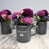 Welcome them with flowers that will last! (price per) large coffee mug with burgundy, orchid pink and blue-gray Sola Wood Flowers arrangment