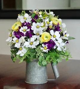 A Vintage Oil Can With Yellow, Purple and White Silk Flower Arrangement