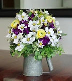 A Vintage Oil Can With Yellow, Purple and White Silk Flower Arrangement