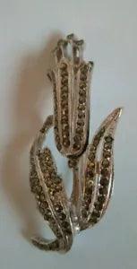 Large Silver Coloured And Dark Gemmed Lily Flower Brooch