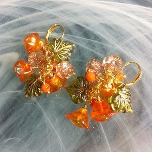 Earrings in a floral bouquet of Czech glass flowers with three petals and small pink flowers with rose gold ribbing and transparent leaves