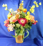 Very Colorful Floral Arrangement In A Beautiful Pitcher With Limes & Oranges