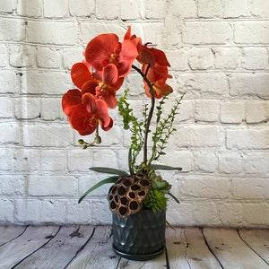Faux red orchid in a black ceramic pot