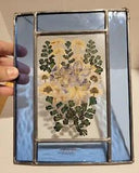 Vintage Wildflower and Co. dried flowers in glass with metal frame wall hanging.