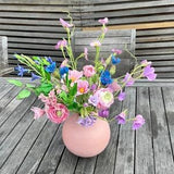 Cold porcelain handmade spring flowers in the pink vase. Wildflowers centerpiece. Cornflowers, cosmos and ranunculus. Realistic flowers