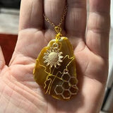 Large tan and brown agate gemstone wrapped in gold wire. Honey comb and sunflower charm. Natural polish agate