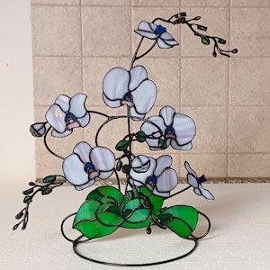 Stained glass orchid, light purple flower with green plant leaves on a metal stand,flower sculpture,consists of several branches, 3D