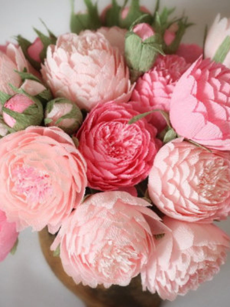 Pink peony-style paper flower bouquet with green leaves