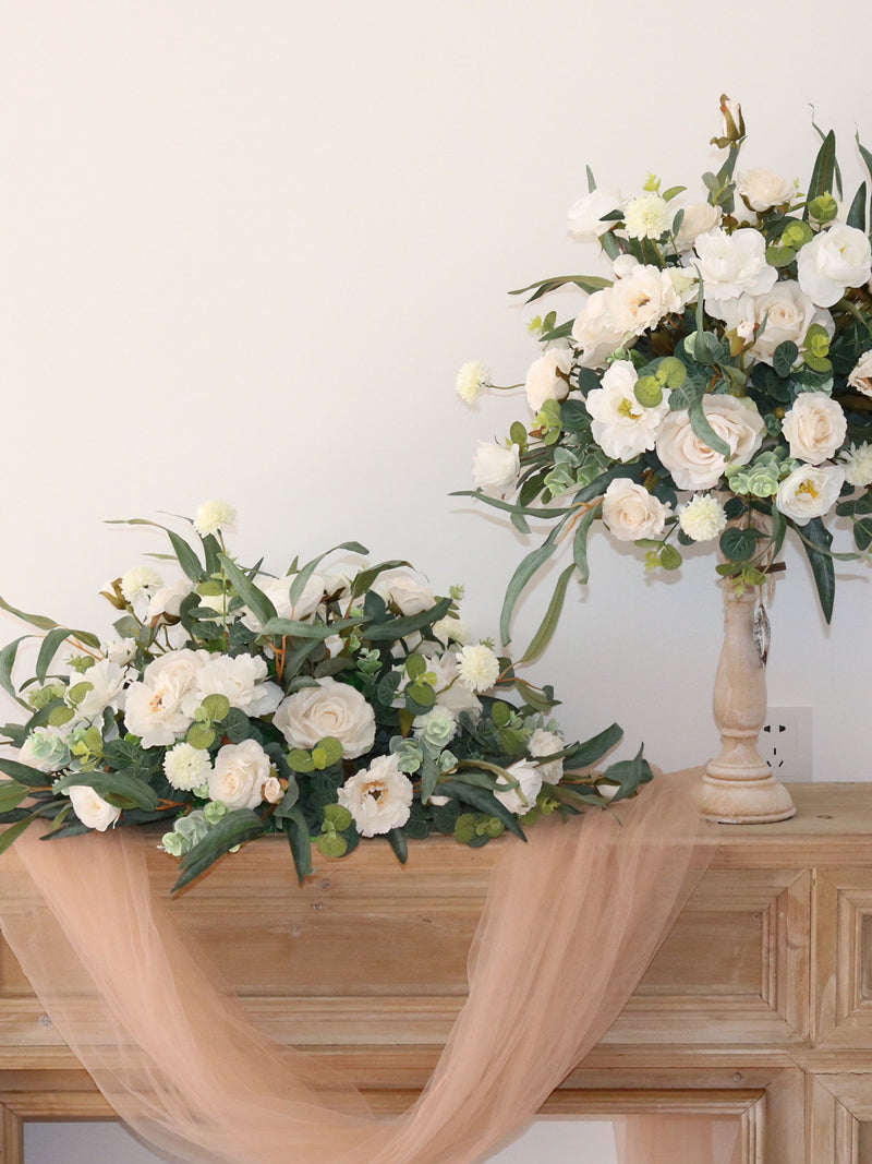 Ivory rose wedding table centerpiece with white blooms, greenery, and tulle drape