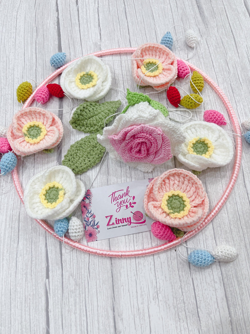 Baby flower mobile with crocheted blooms on a pink circular ring