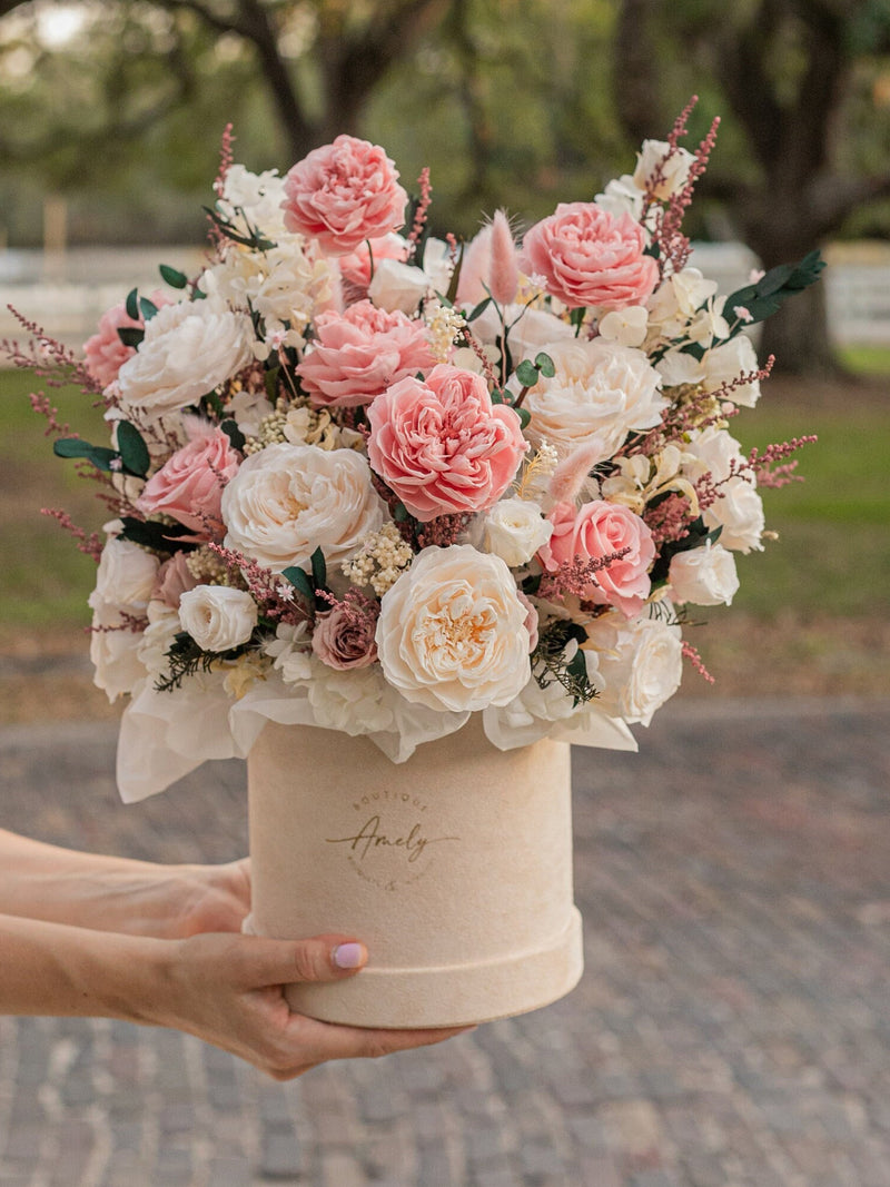 Preserved floral bouquet in cream hatbox with pink and cream roses, greenery, small sprigs