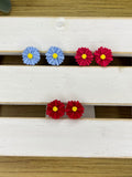 Polymer clay flower stud earrings, blue and red flower shapes with yellow centers