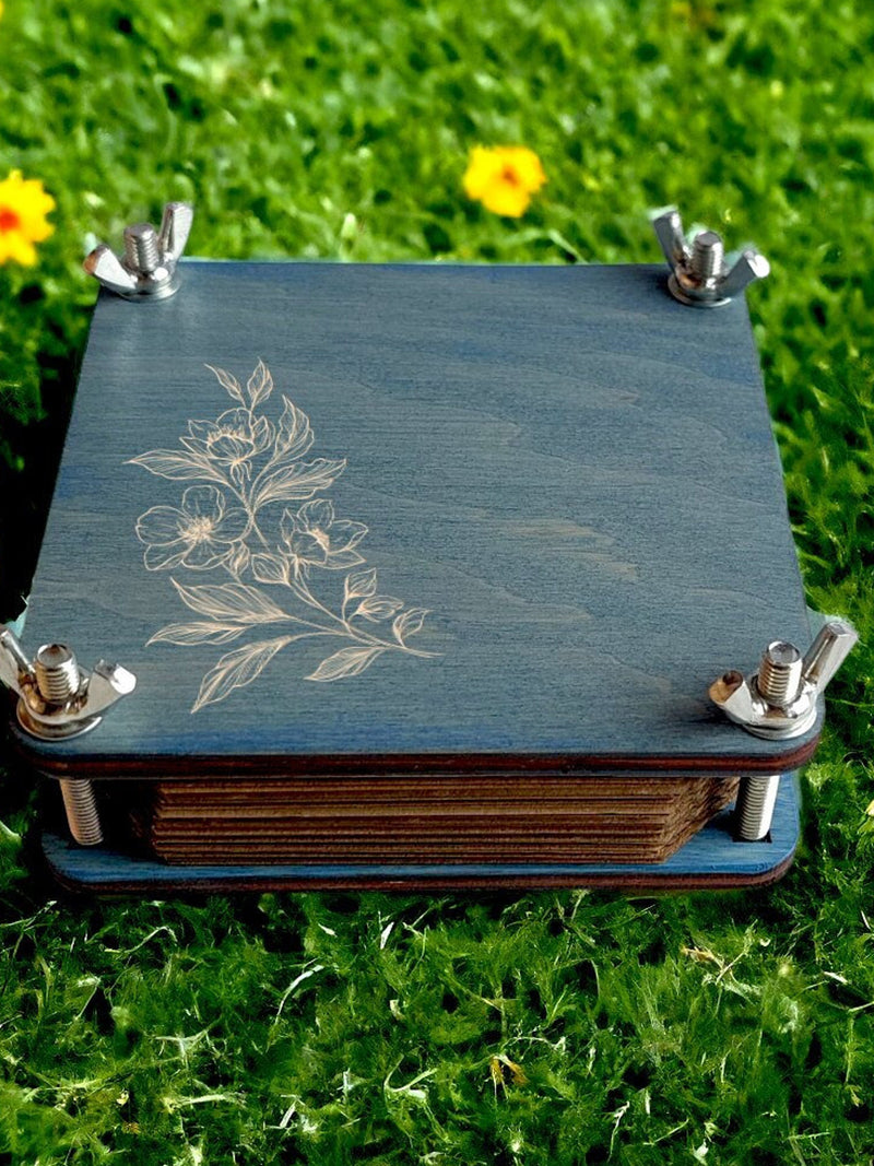 Pocket flower press kit with blue board, pressed flower outline, metal corner clamps, wooden base