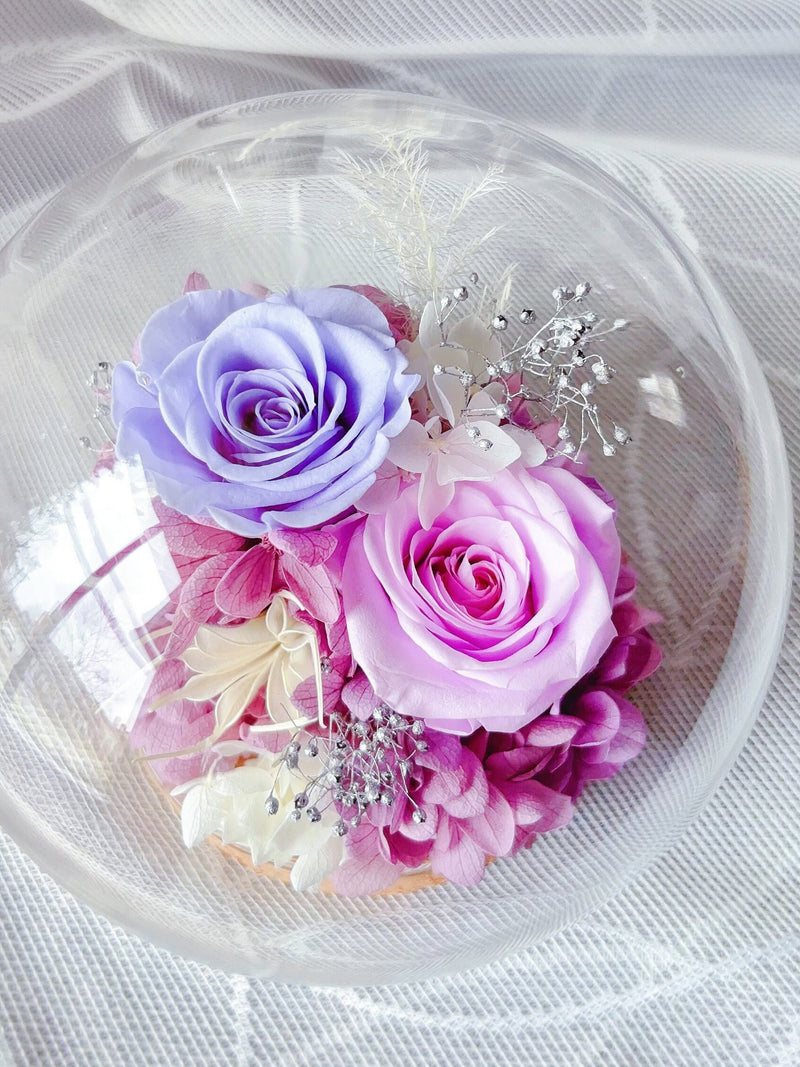 Preserved rose bouquet in clear dome with purple and pink flowers and silver accents