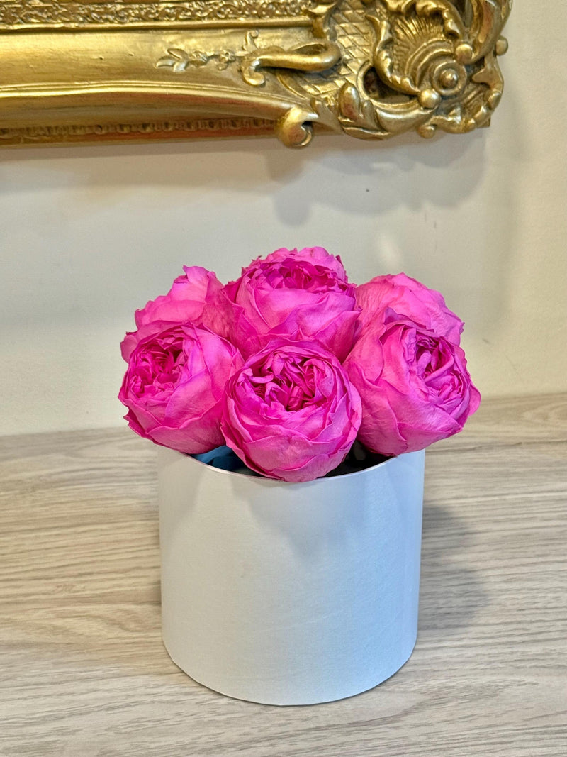 Pink preserved peonies in a white round box arrangement