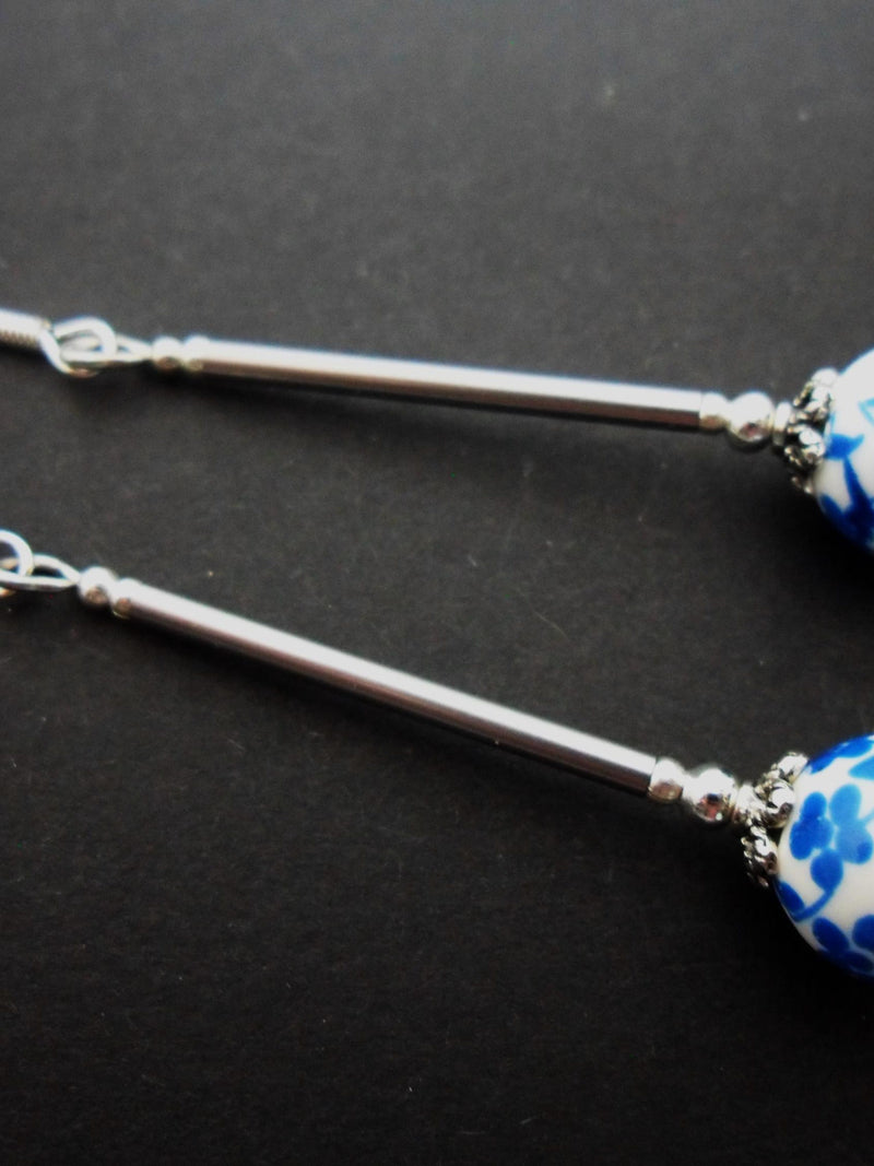 A pair of hand made cute long dangly blue flower porcelain earrings with 925 solid silver hooks. FLOWER DELIVERY
