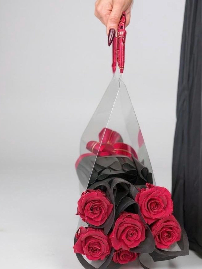 Handbag-style rose bouquet with pink preserved roses in black wrap and pink ribbon