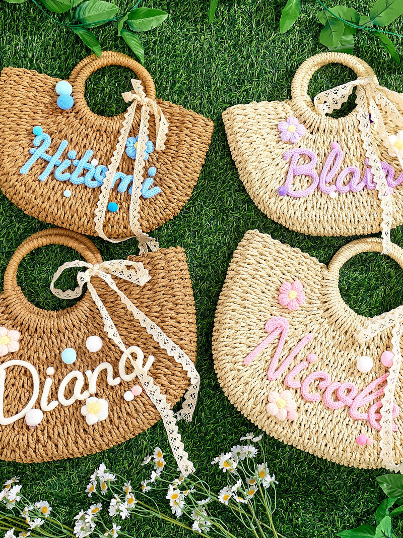 Woven straw beach tote bags with pastel embroidered names and heart handles