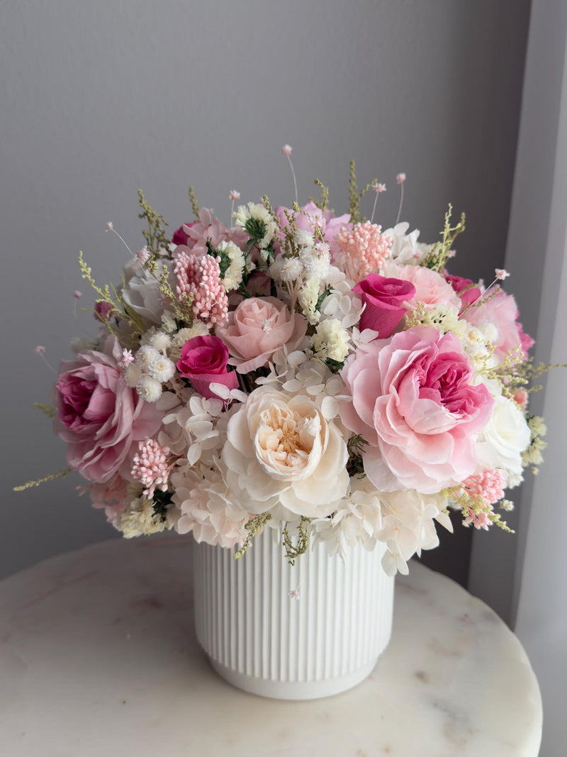 Pastel preserved rose bouquet with wildflowers in white ribbed vase