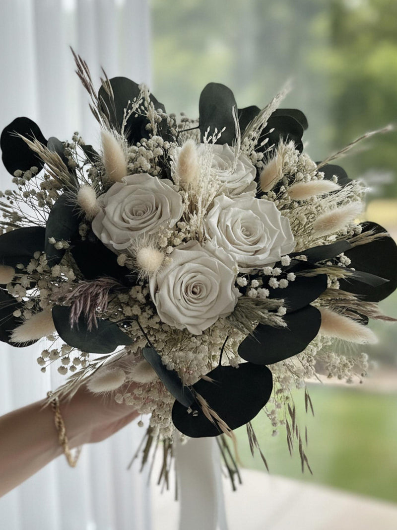 Ivory bridal bouquet with preserved roses, dried blooms, and dark foliage leaves