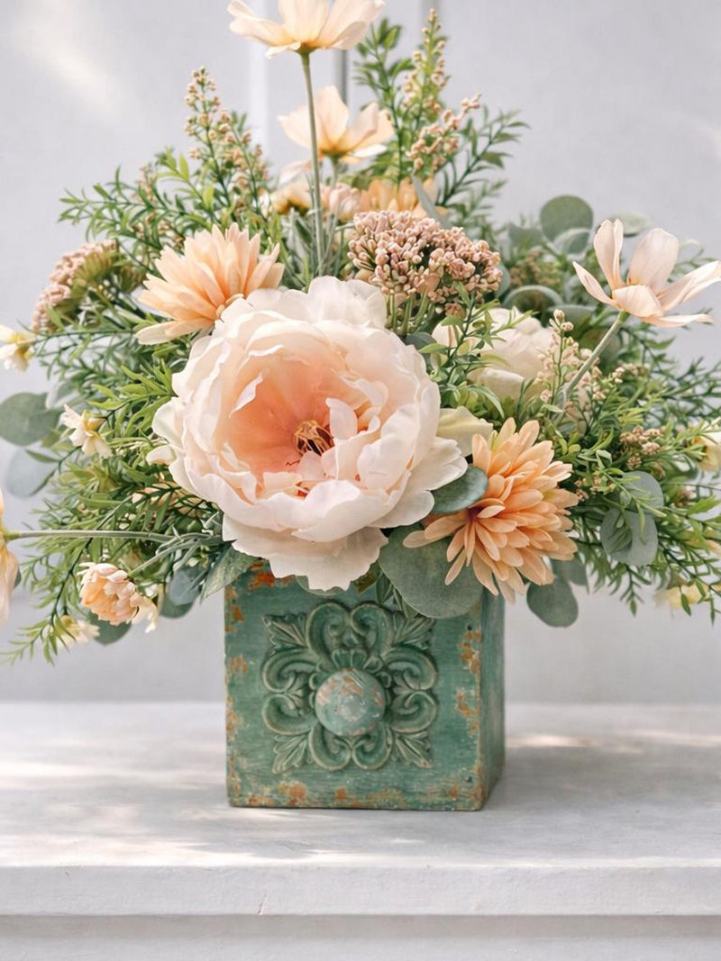 Farmhouse floral centerpiece in green distressed box with peach and cream peonies and greenery