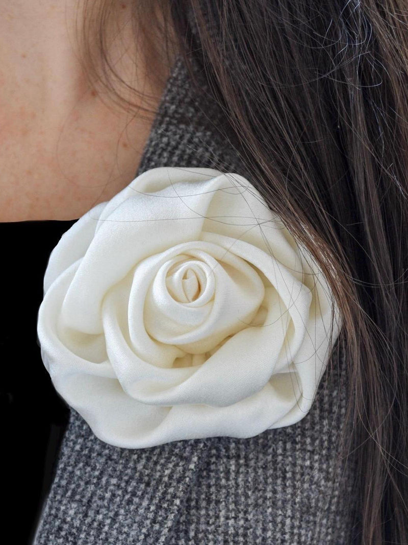 Ivory silk flower brooch with layered rose design on gray blazer lapel