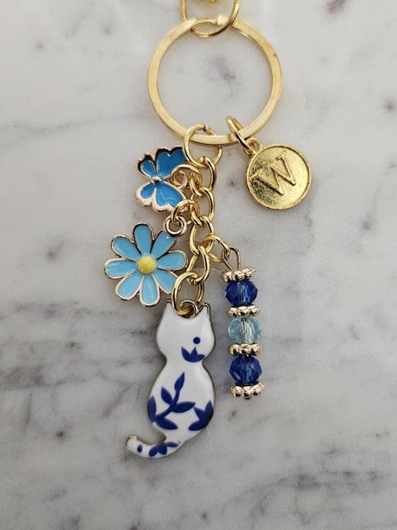 Blue enamel cat charm clip with flower and butterfly accents, crystal beads, round initial pendant