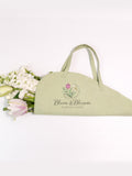 Sage green floral tote bag with printed shop logo and botanical graphic, open-top handles