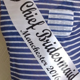 Blue-and-white striped fabric sash with printed script text
