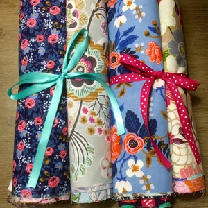 Floral cotton fabric scrap pack in multi-color prints, tied bundles with ribbons.