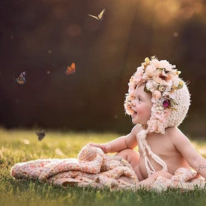Knit baby floral bonnet with pink flower accents and lace ties