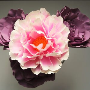 Pink and red paper flower with dark purple layered petals, rose-style blooms