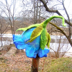 Handmade bell-shaped felt flower hat with blue petals and green leaf accents