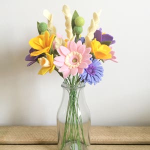 Felt flower bouquet with yellow, pink, purple blooms in clear glass vase
