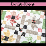 Country flowers quilt pattern featuring square patchwork blocks in green, red, black, and cream