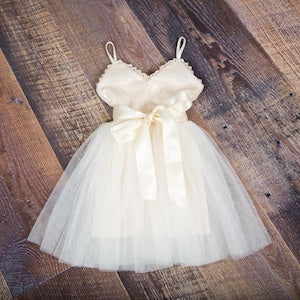 Ivory flower girl dress with lace straps, tulle skirt, satin bow at waist