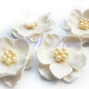 White sugar flower cupcake toppers with pearl ball centers
