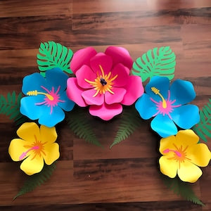 Colorful paper hibiscus flowers with teal, pink, blue, and yellow petals and green leaves