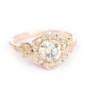 Gold engagement ring with round center stone, art deco halo and split band