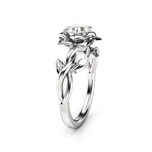 Floral-inspired diamond engagement ring, round center stone in silver prongs