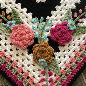 Crochet flower appliqué with pink, magenta, and brown flowers on cream lace