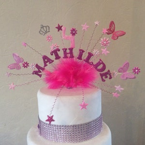 Pink fairy cake topper with sparkly star wands and tutu-style accent on cake
