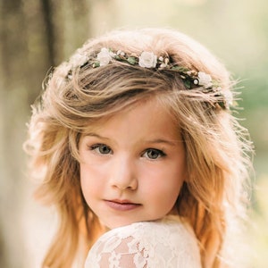 Child flower crown wreath with pale flowers and greenery worn in a loose halo