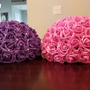 Half moon flower ball centerpiece with pink and purple rose-like blooms
