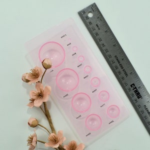 Clear pink plastic mold with circular wells for paper flower making and quilling