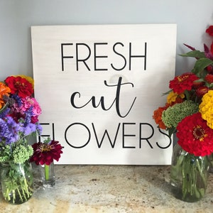 Wooden farmhouse style sign with “Fresh cut flowers” text in black lettering
